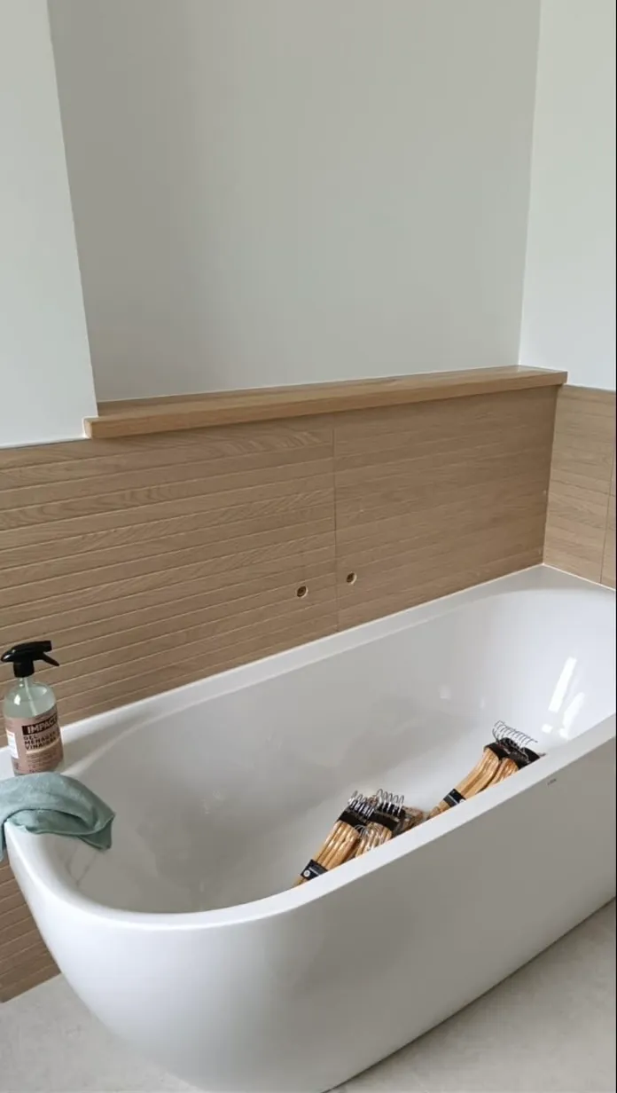 Baignoire îlot avec habillage en bois dans une salle de bain