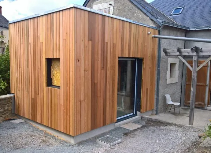 Bardage bois naturel sur une extension accolée à une maison en pierre