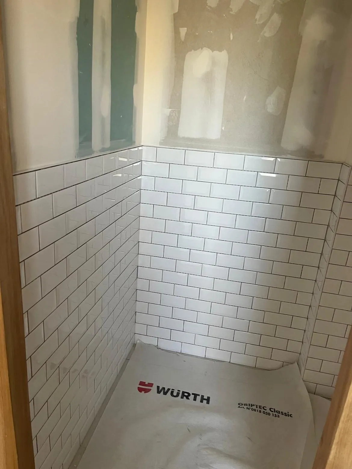 Carrelage métro blanc biseauté posé dans une cabine de douche