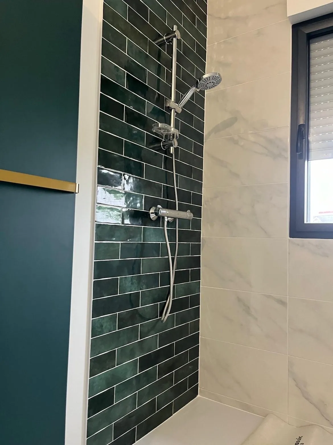Carrelage métro vert et effet marbre blanc posé dans une douche par un artisan carreleur