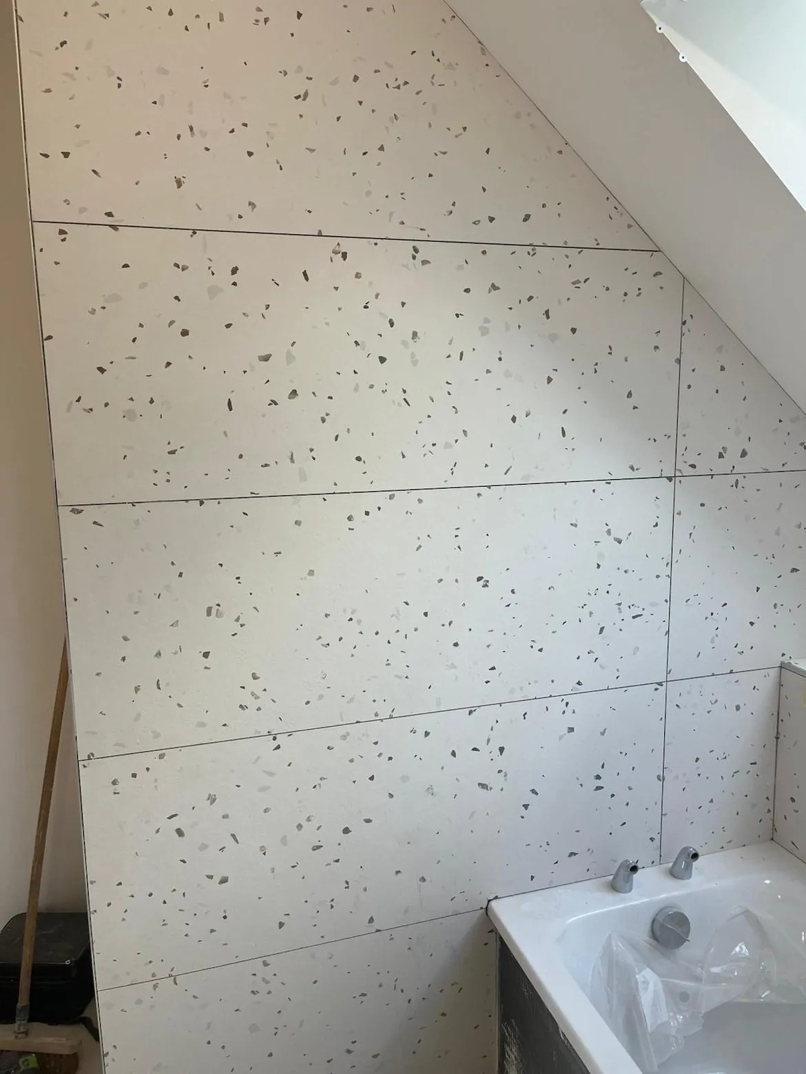Carrelage terrazzo blanc posé sous une pente de toit dans une salle de bain