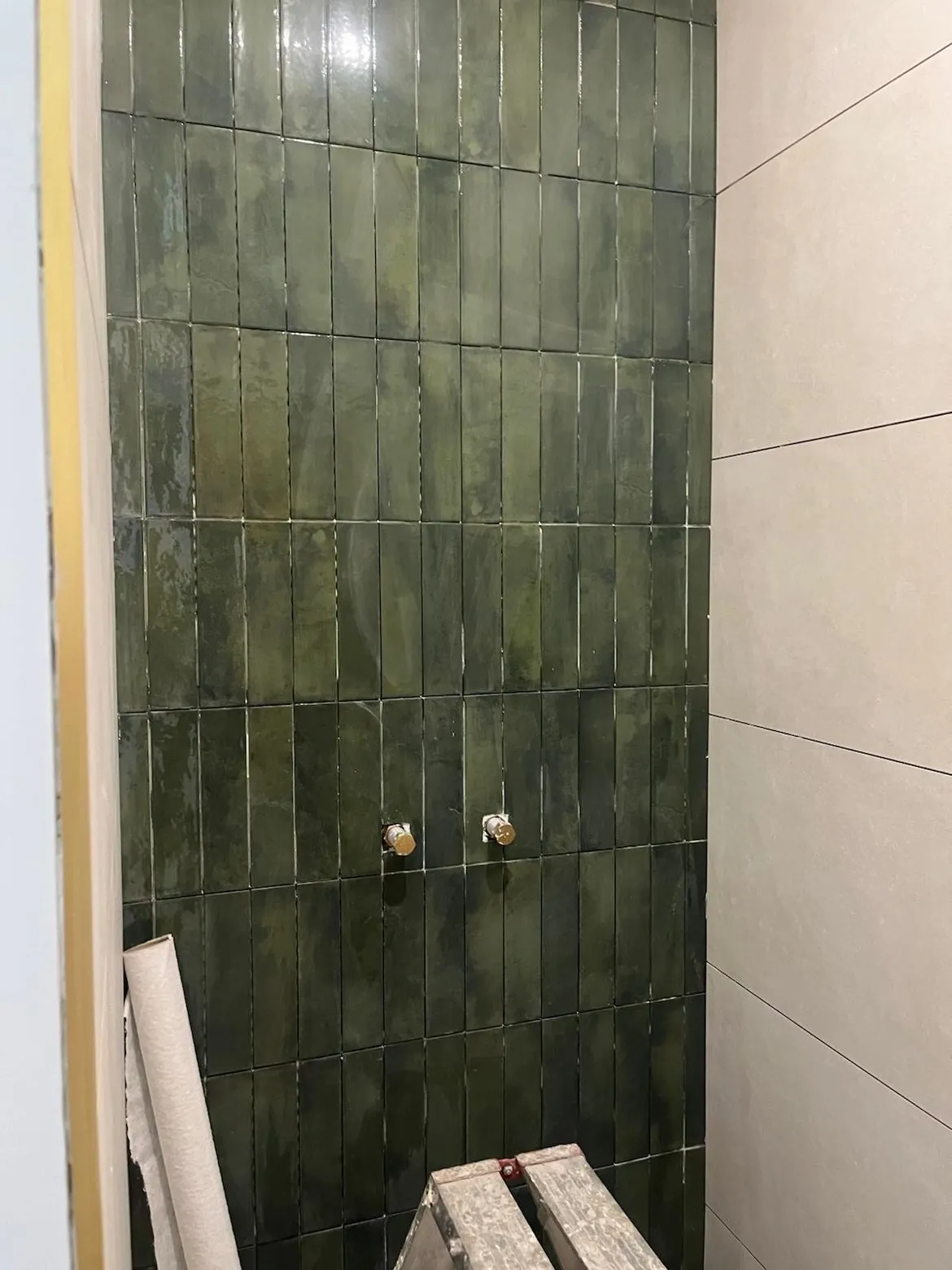 Carreaux zellige vert posés en niche de douche avec faïence beige