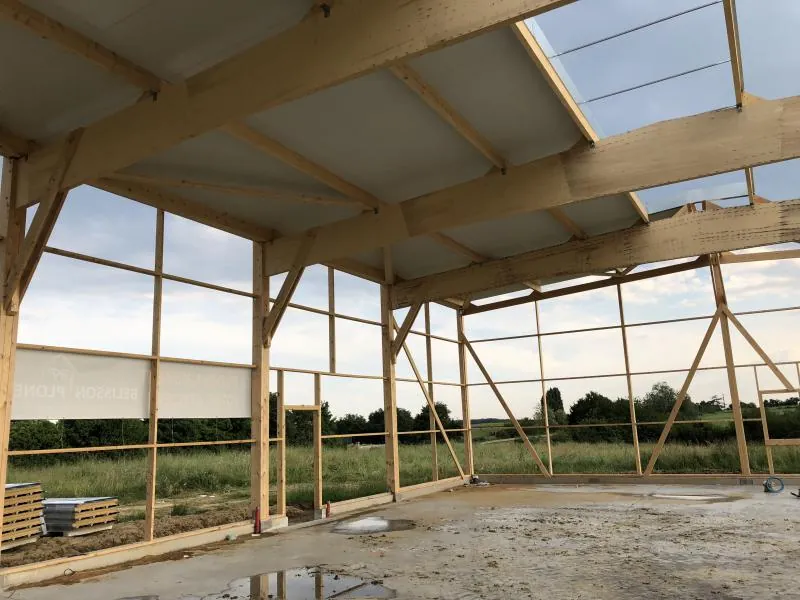 Ossature bois d'un hangar en cours de montage par Belisson Ploneis