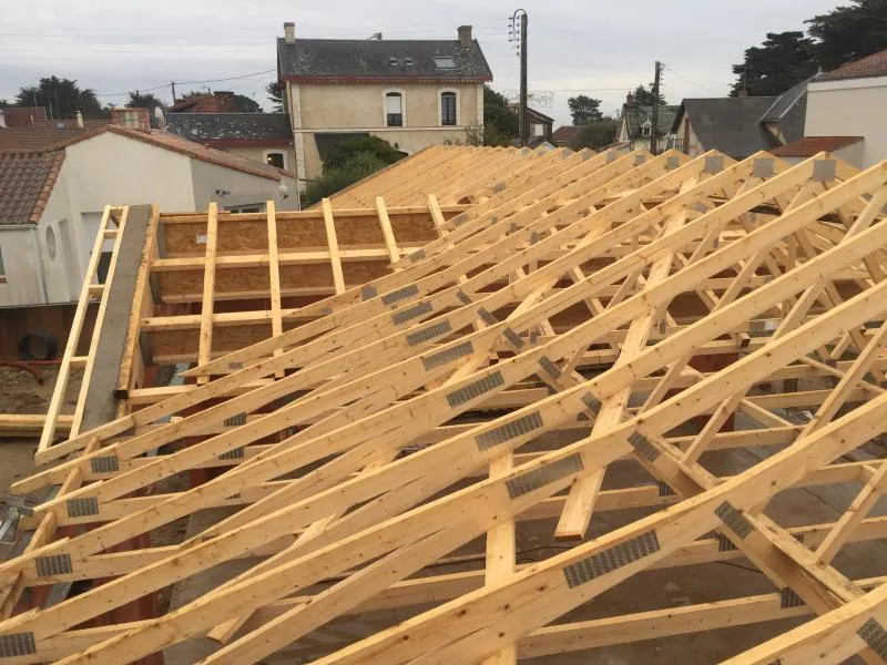 Vue aérienne de fermettes bois posées sur une toiture
