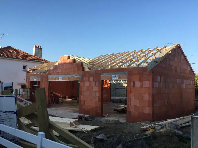 Charpente posée sur une maison neuve en parpaing de terre cuite rouge