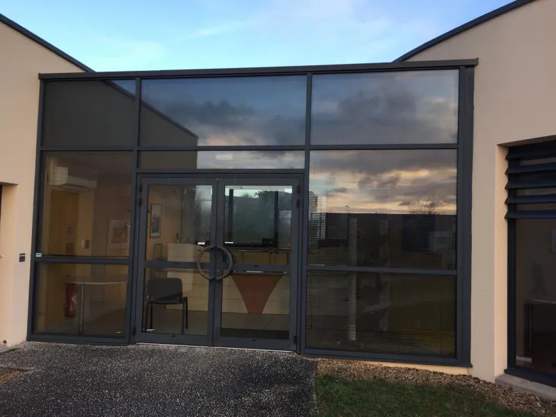 Porte vitrée aluminium à l'entrée d'un bâtiment professionnel