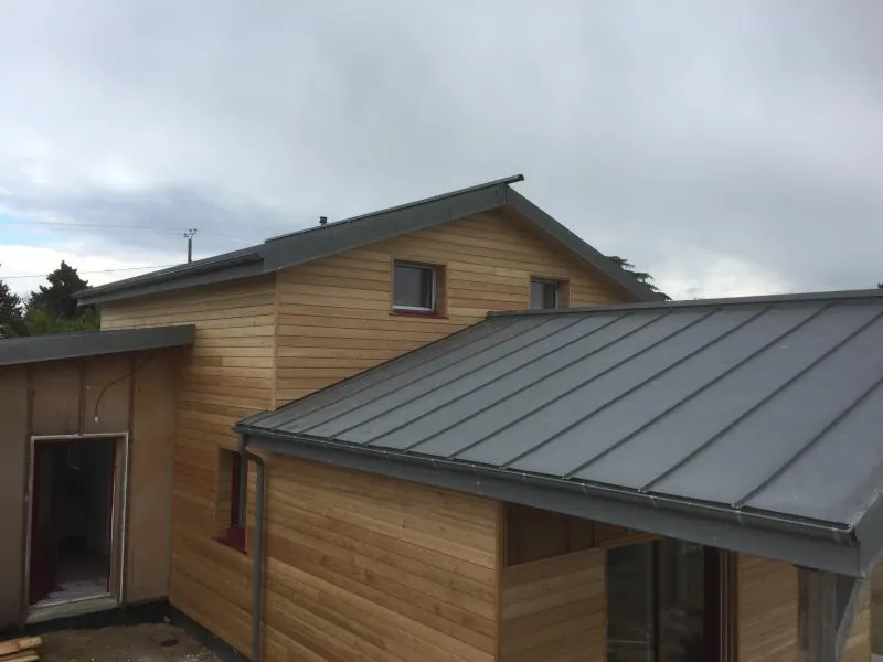 Maison à ossature bois avec bardage clair et toiture en zinc
