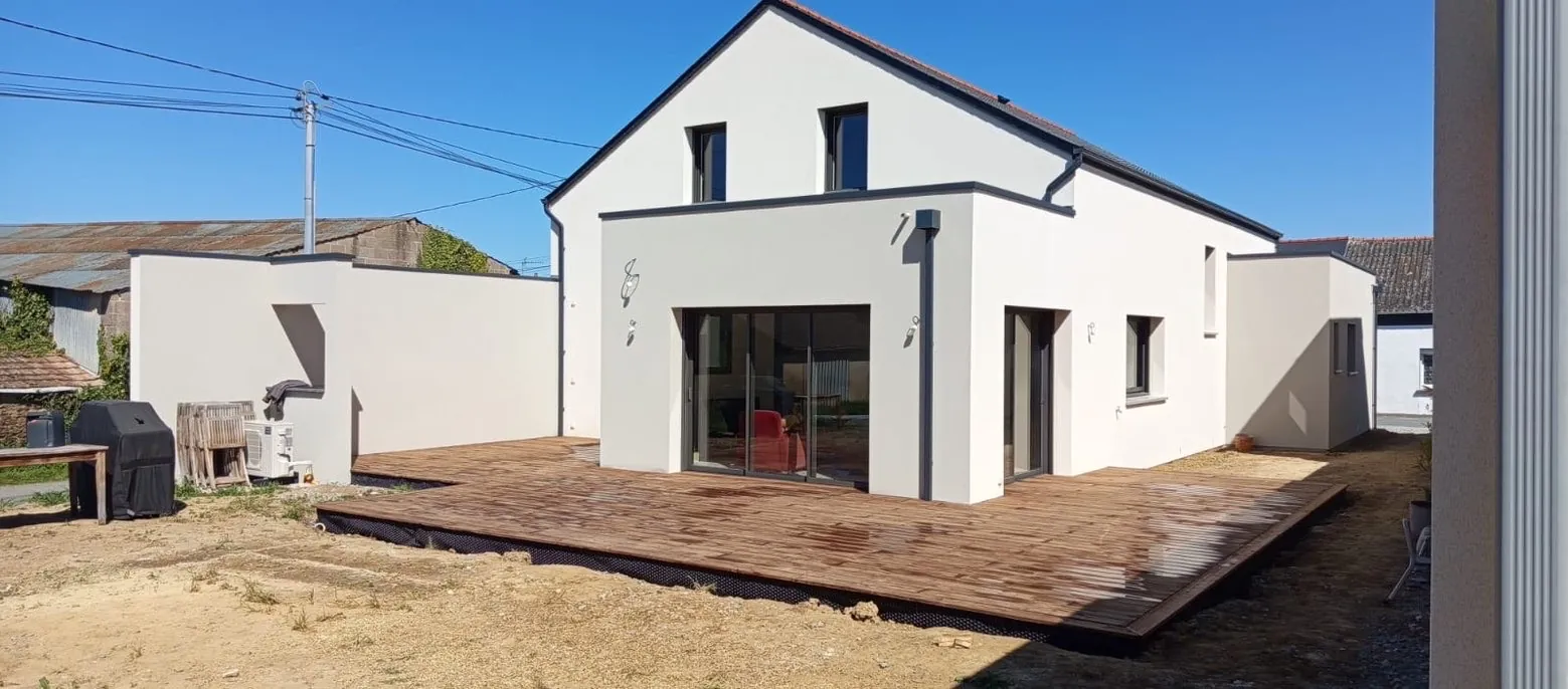 Terrasse en bois attenante à une maison neuve avec baies vitrées