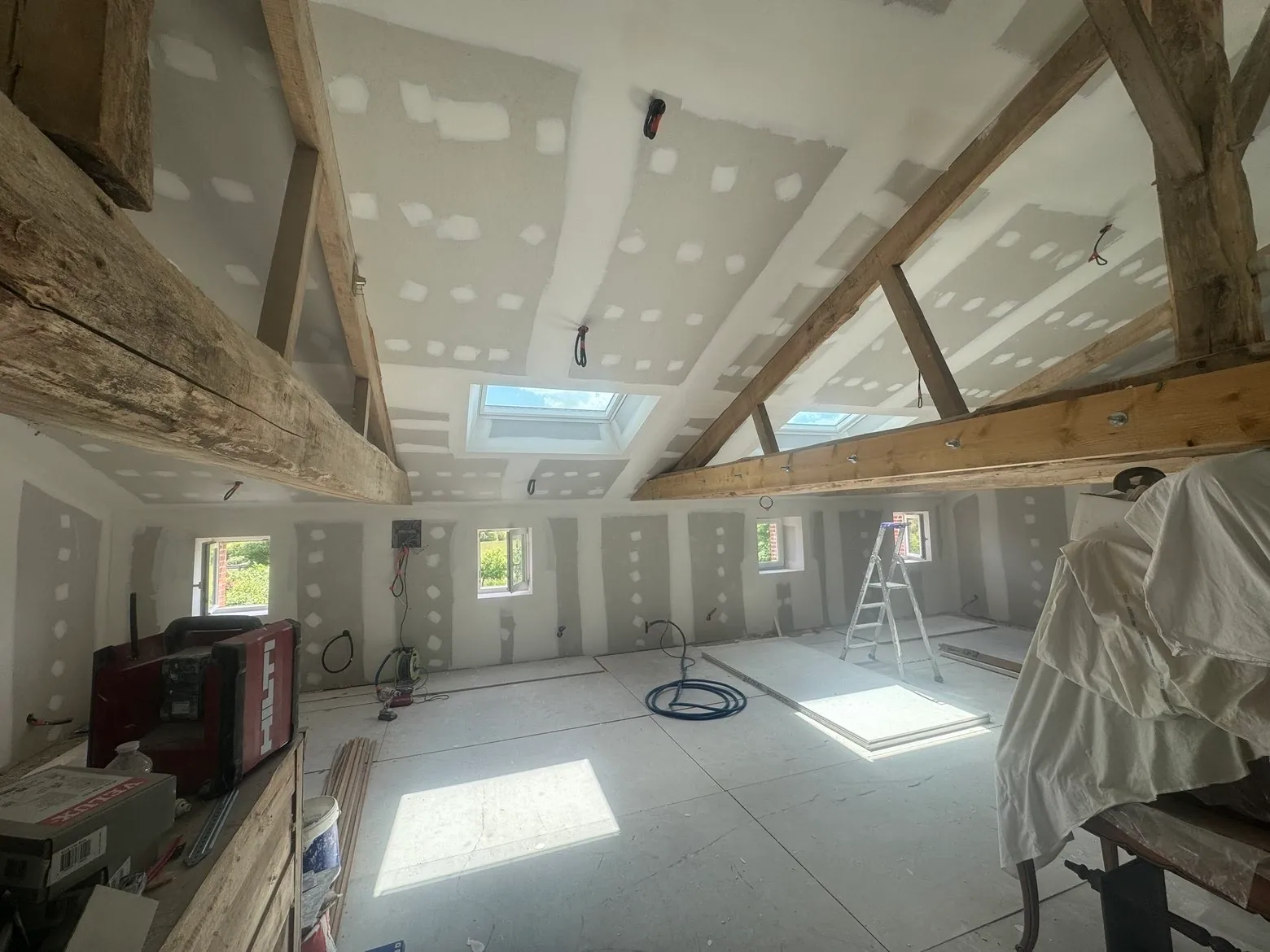 Aménagement de combles avec charpente apparente et fenêtres de toit Velux