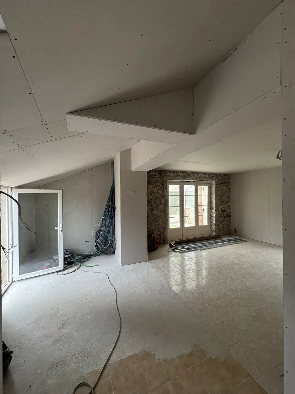 Rénovation de combles avec doublage et mur en pierre ancienne